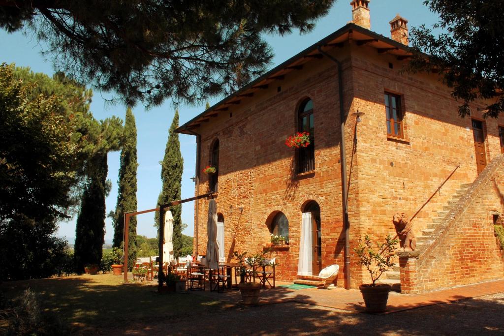 casa in campagna con tavolo all'aperto e cipressi
